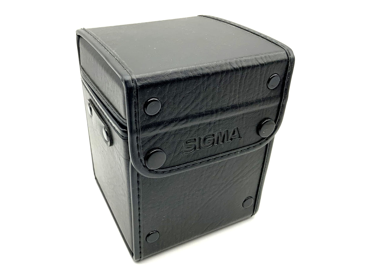 Étui rigide universel Sigma noir pour objectif, env. 14 x 10 cm, de forme rectangulaire.