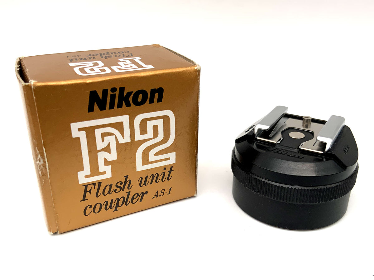Adaptateur de flash Nikon AS-1 pour griffe porte-accessoires F2, dans son emballage d'origine.